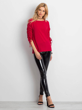 Czerwona bluzka zdobiona ściąganym i wiązanym rękawem