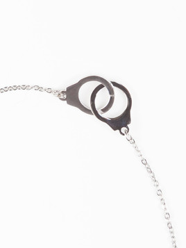Bransoletka na srebrnym łańcuszku zdobiona zawieszkami kajdanki